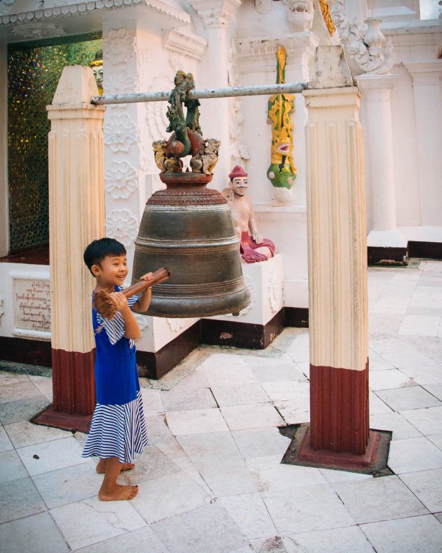 Burmese child ringing buddhist bell