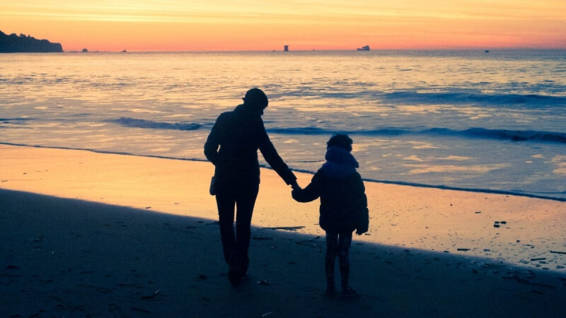 Silhouette mother and child at beach